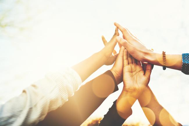 Multi-ethnic hands coming together for a group "high-five"